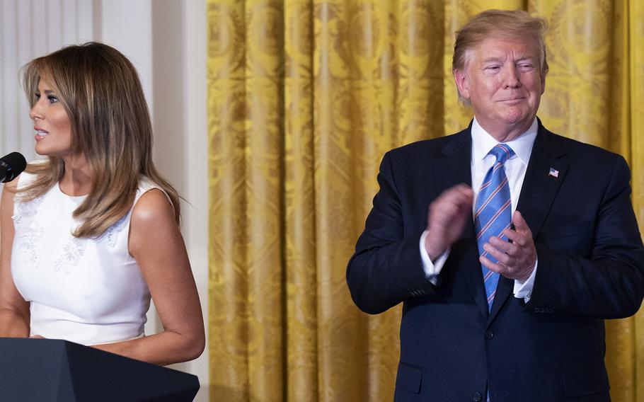 President Donald Trump applauds as first lady Melania Trump speaks at the third annual Celebration of Military Mothers at the White House, May 10, 2019.