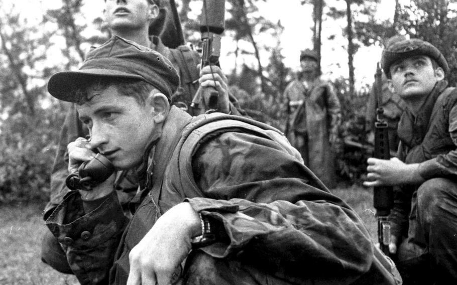 In a photo taken by Steve Kroft in January, 1971, near Combat Base Baldy, squad leader Cpl. Mike Roseberry of Paducah, Ky., calls in gunships as Marines from CUPP6, Golf Co., 5th Marine Regiment, and Popular Forces from Huong Xuan Village come under fire. The radio man at the top of the photo is Lance Cpl. Doug McCarty of Owensboro, Ky.