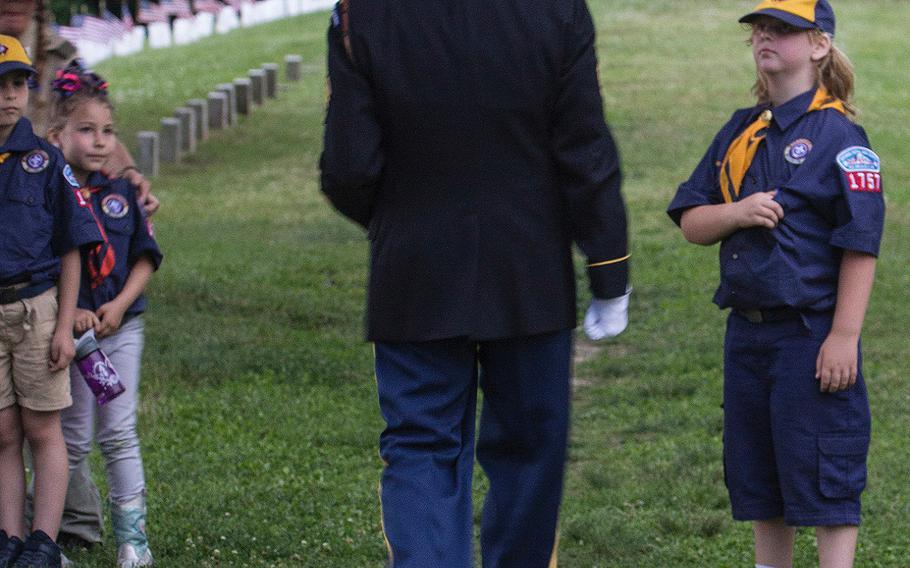 Scouts watch as retired Army Staff Sgt. J.B. Greear walks away after playing taps at the 24th annual luminaria at Fredericksburg National Cemetery in Fredericksburg, Va., May 25, 2019.