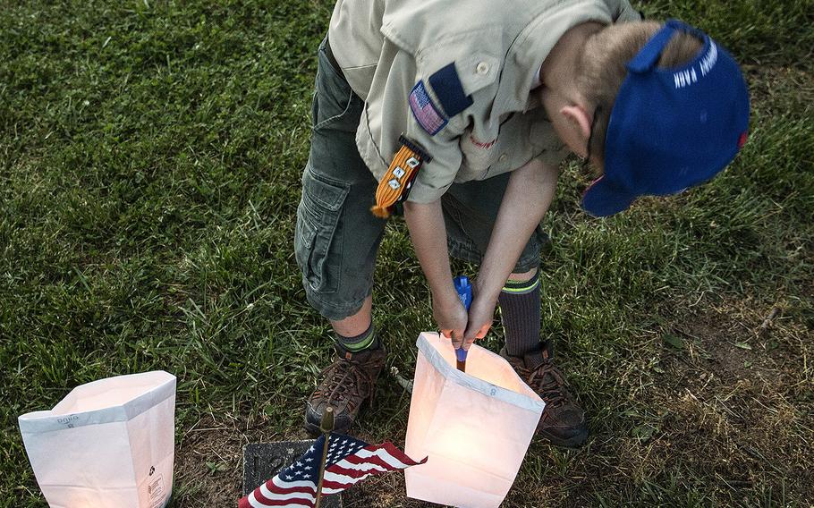 A Scout lights a candle during the 24th annual luminaria at Fredericksburg National Cemetery in Fredericksburg, Va., May 25, 2019.