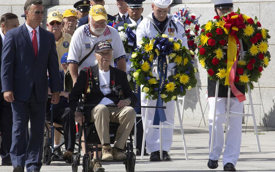 Army veteran Herman Zietchik, center, who stormed Utah Beach with the 4th Infantry Division on D-Day 75 years ago, prepares to place a wreath at the National World War II Memorial in Washington on Memorial Day, May 27, 2019.