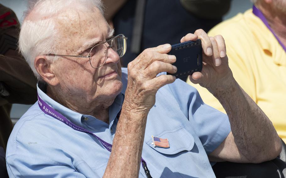 World War II veteran Stan Walsh takes a photo during a ceremony marking the 75th anniversary of D-Day, June 6, 2019 at the National World War II Memorial in Washington, D.C.