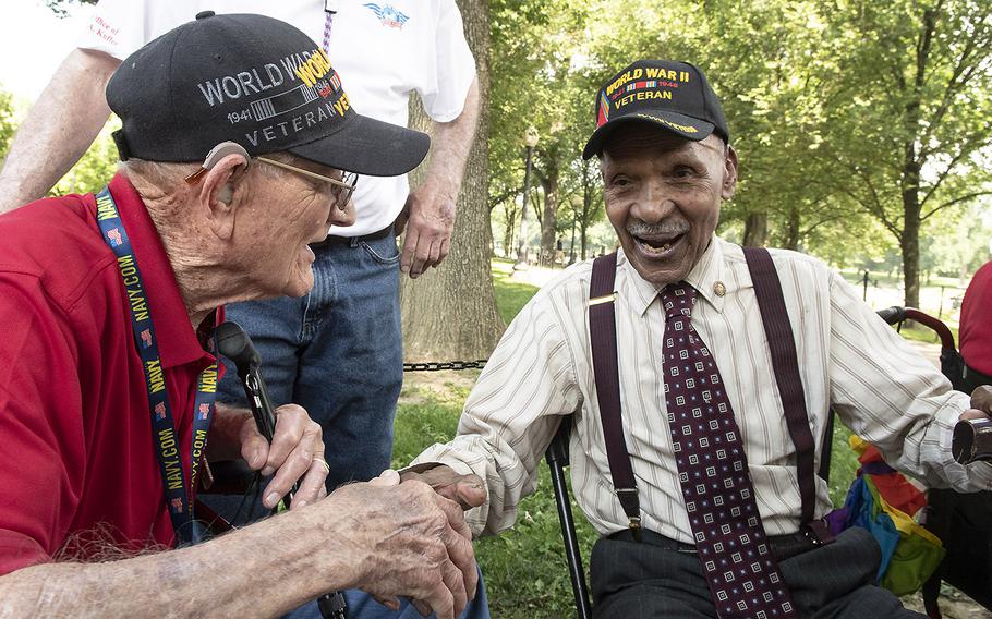 World War II veterans James Keele, left, and Anthony Grant shake hands before a ceremony marking the 75th anniversary of D-Day, June 6, 2019 at the National World War II Memorial in Washington, D.C. Keele was a gunner on the SS John Chandler during the invasion, while Grant served in Quartermaster Corps in Normandy and later fought in the Korean War.
