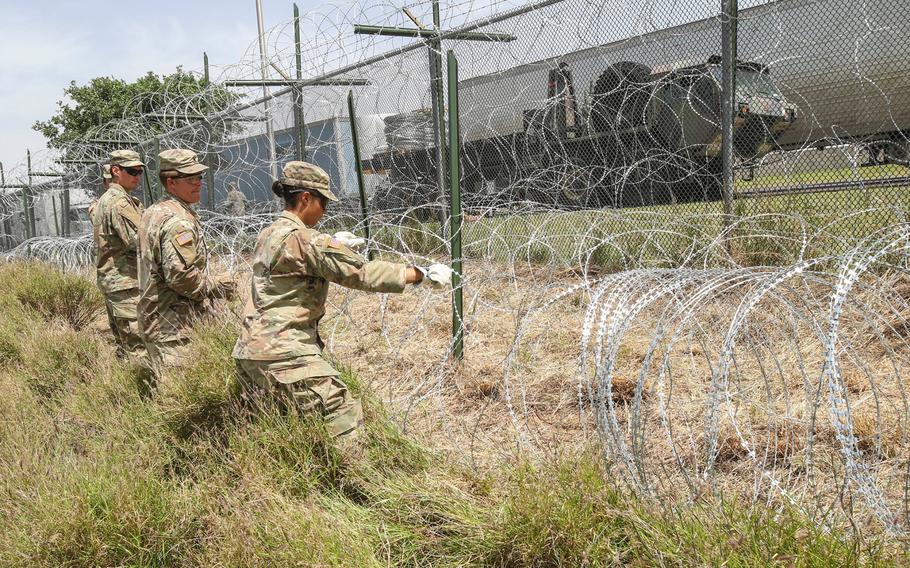 Soldiers from the 161st Engineer Support Company (Airborne) stretch out concertina wire used to secure the existing border fence near the World Trade International Bridge in Laredo, Texas, April 11, 2019.