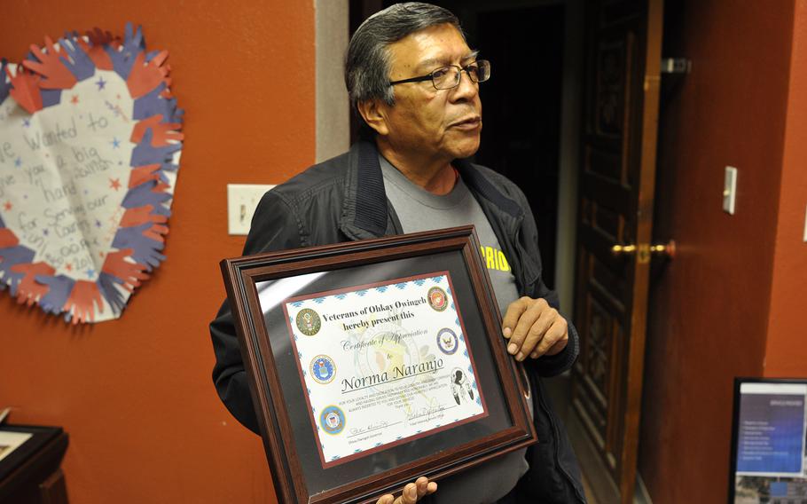 Michael Montoya, an advocate for veterans in Ohkay Owingeh, N.M., holds up one of the certificates he planned to present to a returning veteran from his pueblo. When veterans and servicemembers return to Ohkay Owingeh, they’re often treated to the traditional Butterfly Dance, which Montoya said promotes healing. 