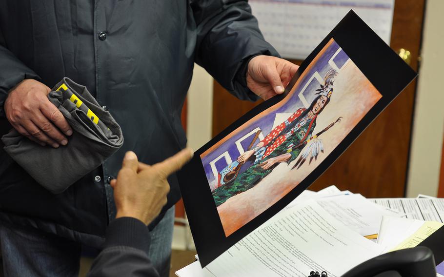 Paul Sullivan, who works in veteran outreach for the law firm Bergmann & Moore, picks up artwork Wednesday, Nov. 7, 2018, depicting a Native American servicemember. Prior to the 9/11 terrorist attacks, American Indians served in the military at a higher rate than veterans of any other race, according to VA data.