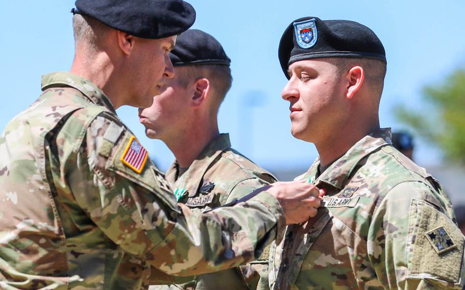 Spc. Joseph Smith, a combat medic assigned to 1st Battalion, 12th Infantry Regiment, 2nd Infantry Brigade Combat Team, 4th Infantry Division, receives an award from Col. Dave Zinn, then commander of 2nd IBCT, June 11, 2019, during an awards ceremony at Fort Carson.