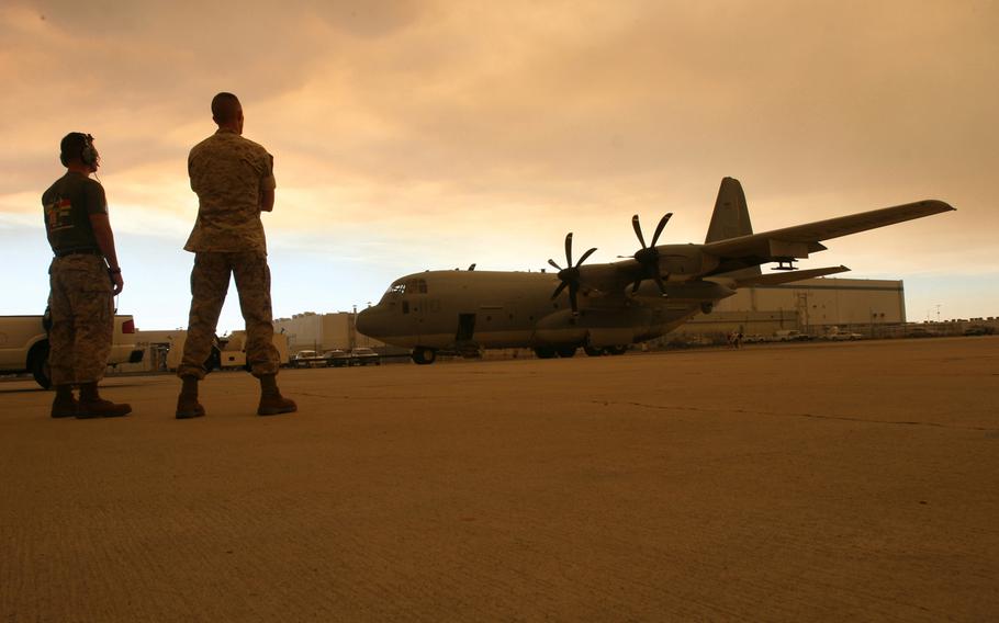 Marines from Marine Aerial Refueler Transport Squadron 352 stand ready to assist powering down a KC-130J "Super Hercules," after its first flight with the new Harvest Hawk mission kit at Air Force Plant 42, Aug. 29, 2009.  