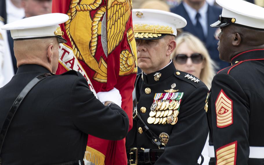 Retiring United States Marine Corps Commandant Gen. Robert Neller, left, presents the Marine colors to Gen. David Berger, who became the 38th Commandant of the Corps during a passage of command ceremony at Marine Barracks Washington, D.C., July 11, 2019. At right is Sergeant Major of the Marine Corps Ronald L. Green