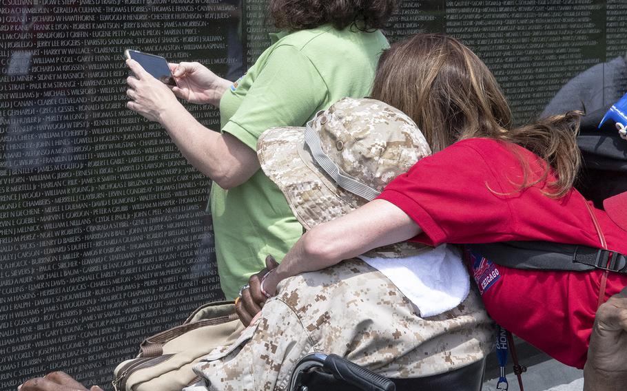 Teri Campbell, a member of Honor Flight Chicago's medical team, hugs Vietnam veteran James Blue as they look at the Vietnam Veterans Memorial in Washington, D.C. on Wednesday, July 10, 2019.