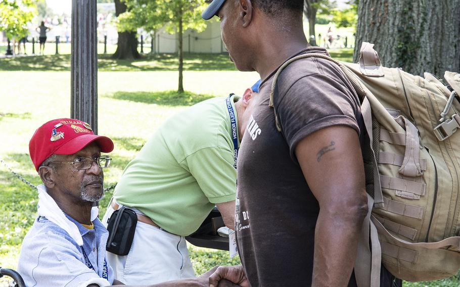 Vietnam veteran Charles Nelson, left, shakes the hand of a passerby near the Vietnam Veterans Memorial in Washington, D.C. on Wednesday, July 10, 2019.
