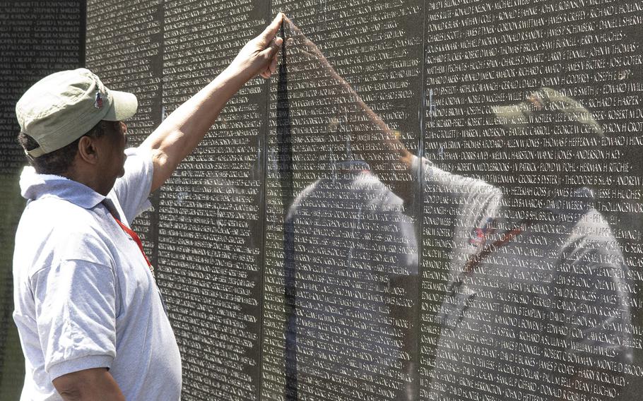 While visiting the Vietnam Veterans Memorial in Washington, D.C. on Wednesday, July 10, 2019, a veteran points to a name on the wall. 