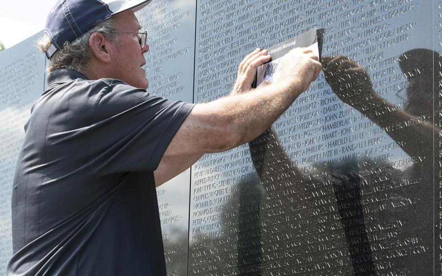 A volunteer at the Vietnam Veterans Memorial in Washington, D.C., makes a rubbing of a name for a vet who was visiting the memorial on Wednesday, July 10, 2019 as part of Honor Flight Chicago's 92nd flight.