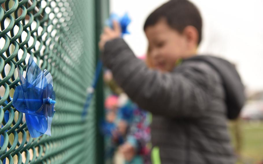 Children place pinwheels on a fence at Malmstrom Air Force Base, Mont., on April 11, 2019, during Child Abuse Prevention Month.