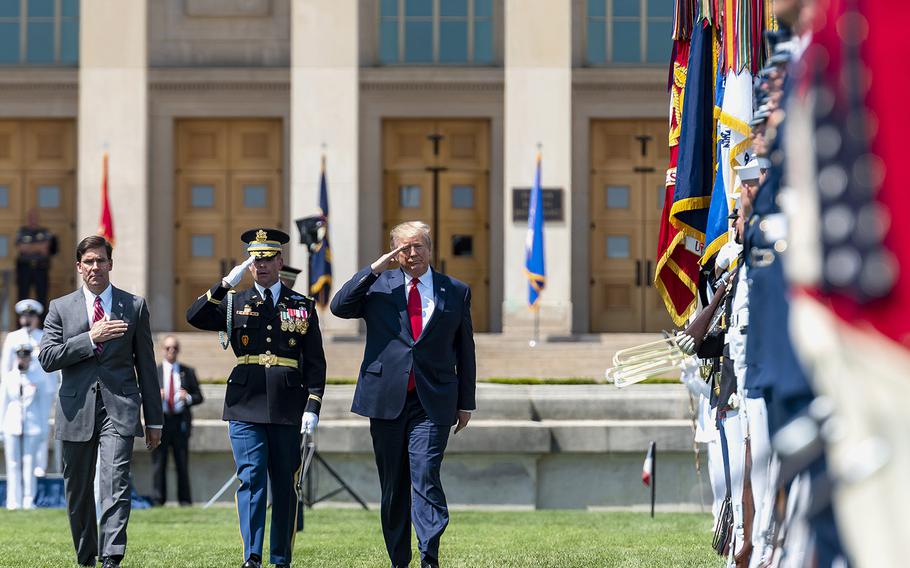 New Defense Secretary Mark Esper, left, Army Col. James Tuite, and President Donald Trump inspect U.S. military troops during a ceremony honoring Esper on the Pentagon parade grounds on Thursday. Esper was sworn in as Trump's second Pentagon chief on Tuesday, ending a more than seven month period in which the Defense Department was led by acting leaders.