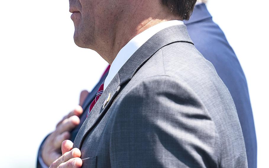Defense Secretary Mark Esper holds his hand over his heart during the playing of the national anthem Thursday outside the Pentagon. Esper was honored by President Donald Trump in a ceremony marking his swearing in as the 27th Pentagon chief this week.