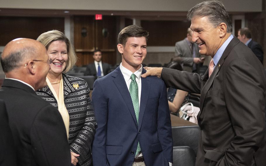 Sen. Joe Manchin, D-W. Va., right, talks with Vice Adm. Michael M. Gilday, left, and his family before a Senate Armed Services Committee hearing on Gilday's nomination to serve as Chief of Naval Operations, July 31, 2019 on Capitol Hill.