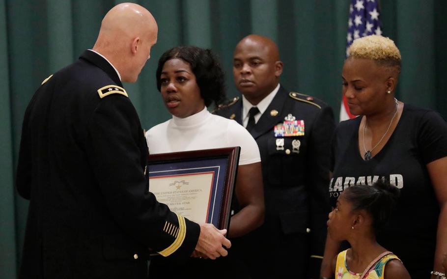 Maj. Gen. John Deedrick, left, presents a plaque to Myeshia Johnson, the widow of Sgt. LaDavid Johnson, during a ceremony awarding the Silver Star Medal to LaDavid Johnson, Friday, Aug. 16, 2019, in Miami Gardens, Fla. Johnson was killed in action during operations in Niger in 2017. At right is LaDavid Johnson's' mother Cowanda Jones- Johnson, and daughter Ahleesya.