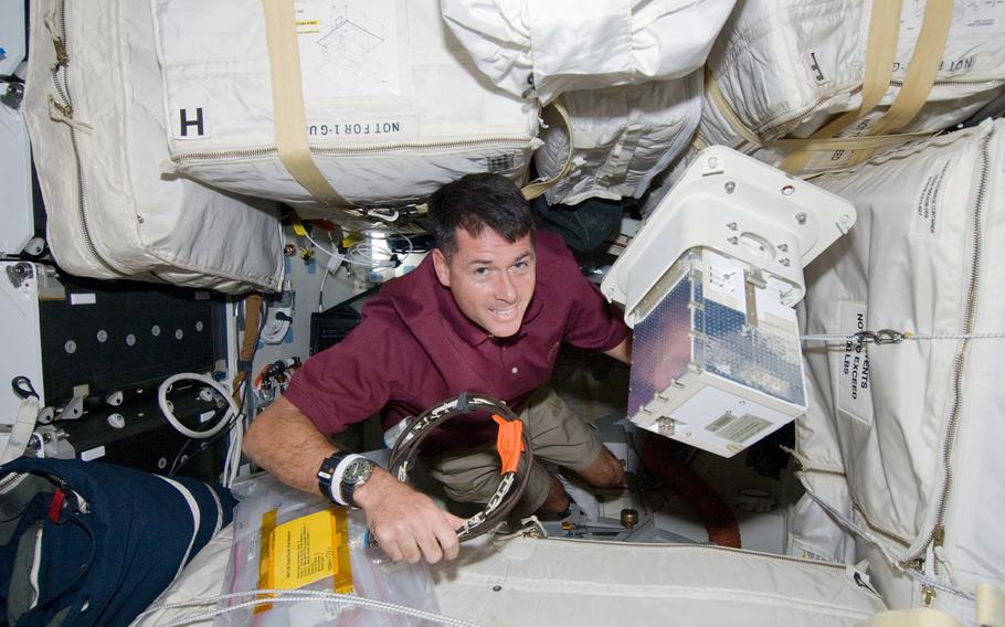 Mission specialist Shane Kimbrough moves equipment among stowage bags on the mid-deck of the orbiter Endeavour on mission STS-126. Kimbrough is a retired Army colonel.

