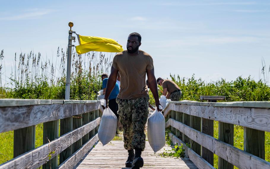 Ship's Serviceman 1st Class Carl Miller carries sand bags on Naval Station Mayport in preparation for Hurricane Dorian on August 29, 2019. 