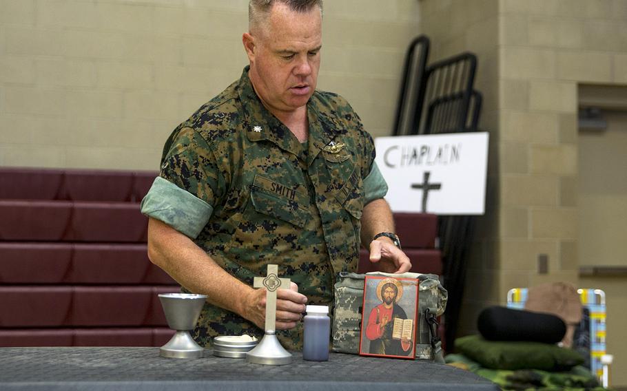 U.S. Navy Cmdr. Patrick W. Smith, chaplain, Marine Corps Air Station New River, prepares an altar at the New River Fitness Center, which is serving as a hurricane shelter on MCAS New River, N.C., Sept. 5, 2019.