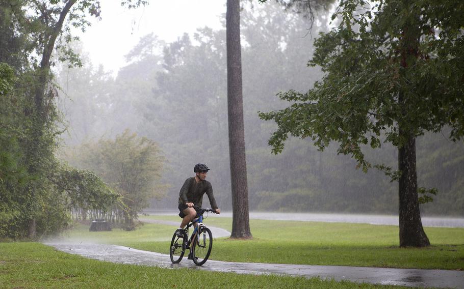 A bike rider travels along a trail in light rain ahead of Hurricane Dorian at Marine Corps Base Camp Lejeune, N.C.