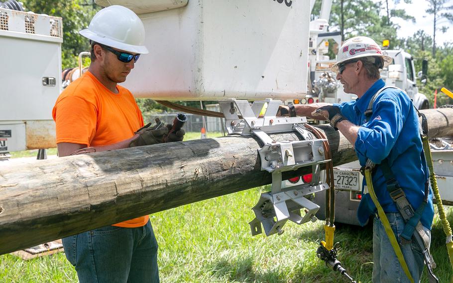 Contracted construction workers replace a damaged power line at Marine Corps Base Camp Lejeune, N.C., Sept. 6, 2019.
