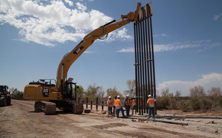 A U.S. Army Corps of Engineers Task Force Barrier contractor installs the first barrier panel at the Yuma project site, near Yuma, Ariz., on Sept. 5, 2019. Pentagon officials confirmed on Wednesday, Sept. 11, that Defense Secretary Mark Esper has approved troop deployments along the US-Mexico border through 2020.