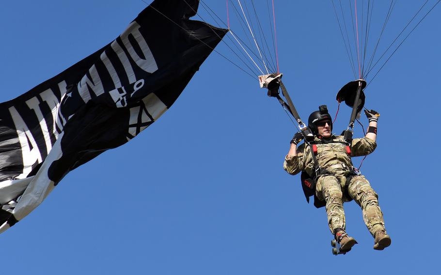 U.S. Army Master Sgt. Chris Malone, of the U.S. Army Special Operations Command Black Daggers parachute team, flies the Prisoner of War/Missing in Action flag as he jumps over the Pentagon on Friday, Sept. 20, 2019 during the National POW/MIA Recognition Ceremony.
