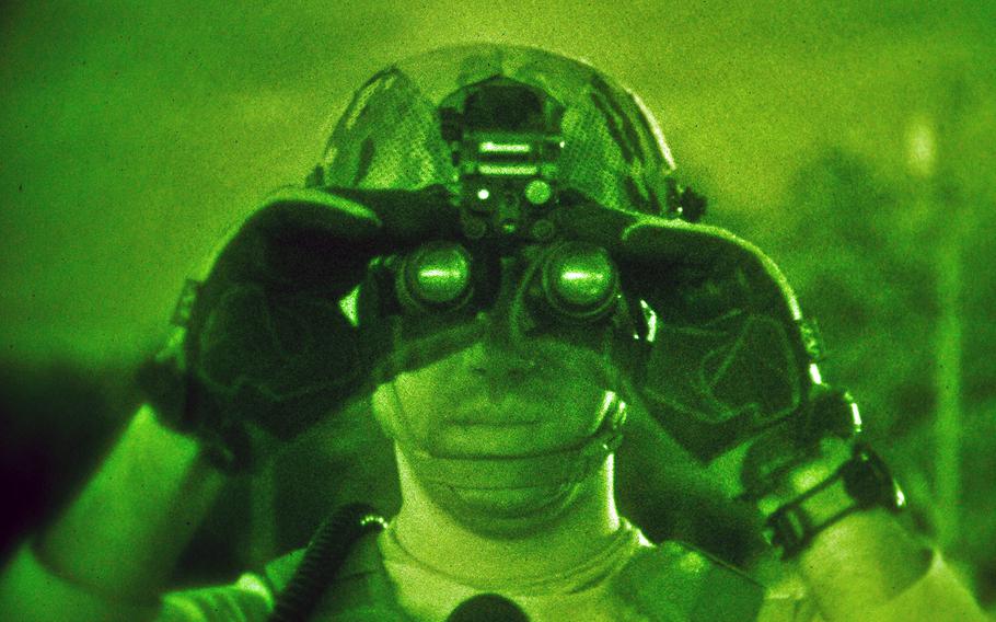 An Air Force officer adjusts his night vision goggles on April 10, 2014, at Fort Dix, N.J. On Thursday, Aug. 28, 2014, the Air Force said it beefed up the aerial search for a missing pilot with the addition of an HC-130 aircraft specially equipped for low-light and nighttime search and rescue missions.