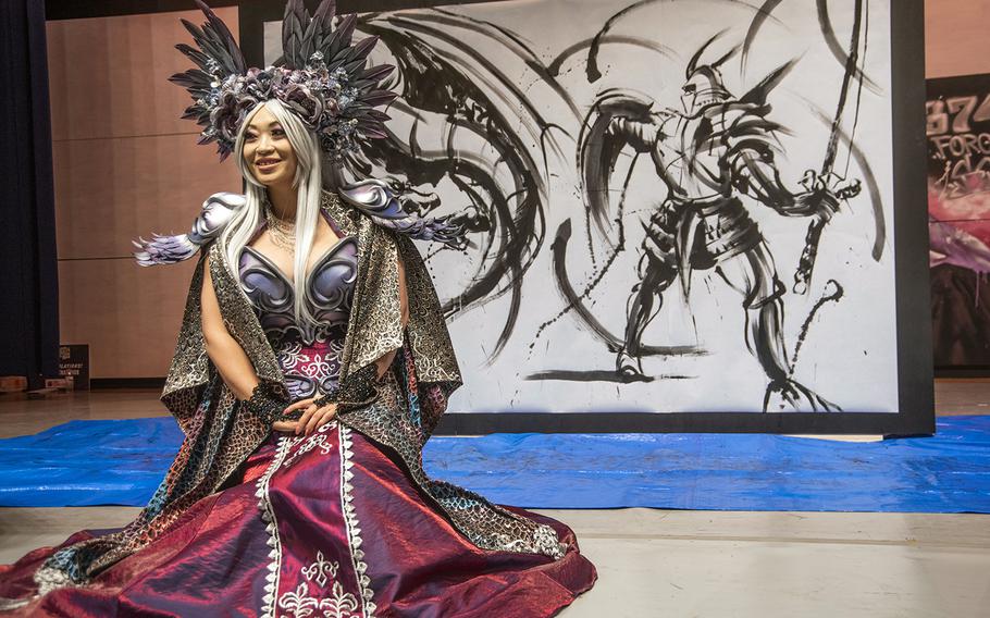 Famous cosplayer and Yokota-Con guest Yaya Han poses in front of a work by painter Hidekichi Shigemoto during the convention at Yokota Air Base, Japan, Saturday, Oct. 19, 2019. 