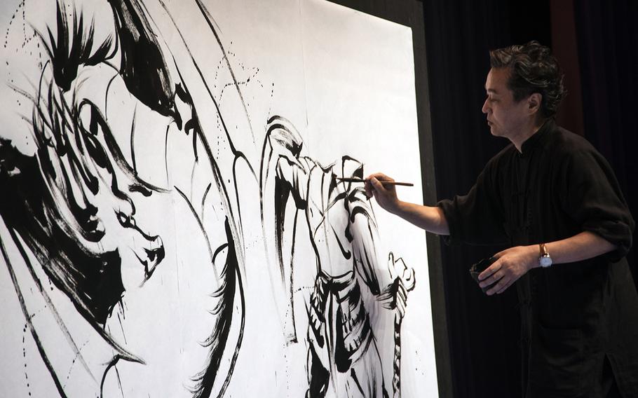 Internationally celebrated ink artist Hidekichi Shigemoto paints a fantasy scene during Yokota-Con at Yokota Air Base, Japan, Saturday, Oct. 19, 2019.
