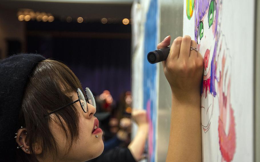 Japanese graphic designer and illustrator Moco works in the Yokota-Con artist alley at Yokota Air Base, Japan, Saturday, Oct. 19, 2019. 