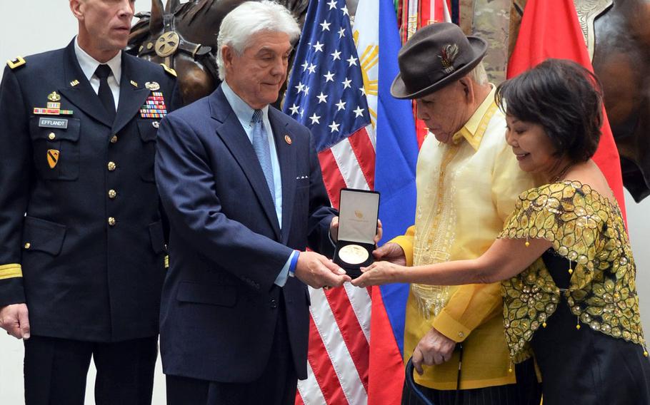 Rep. Roger Williams, R-Texas, presents Jose Manzano-Somera, a former private in the Philippine Scouts of the U.S. Army, with a Congressional Gold Medal during a ceremony Friday at Fort Hood, Texas. Maj. Gen. Scott Efflandt, III Corps special assistant to the commanding general, far left, and the veteran's wife Elizabeth Manzano-Somera look on.