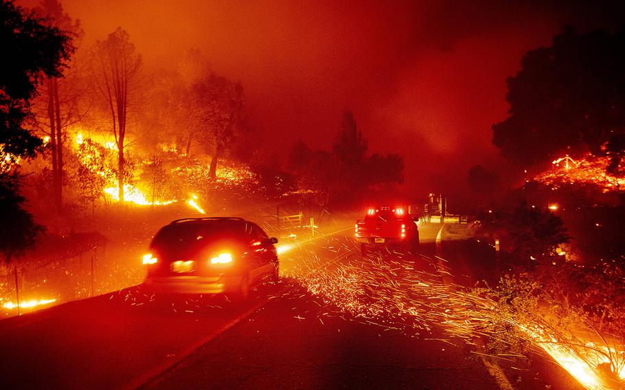 Embers fly across a roadway as the Kincade Fire burns through the Jimtown community of Sonoma County, Calif., Oct. 24, 2019.