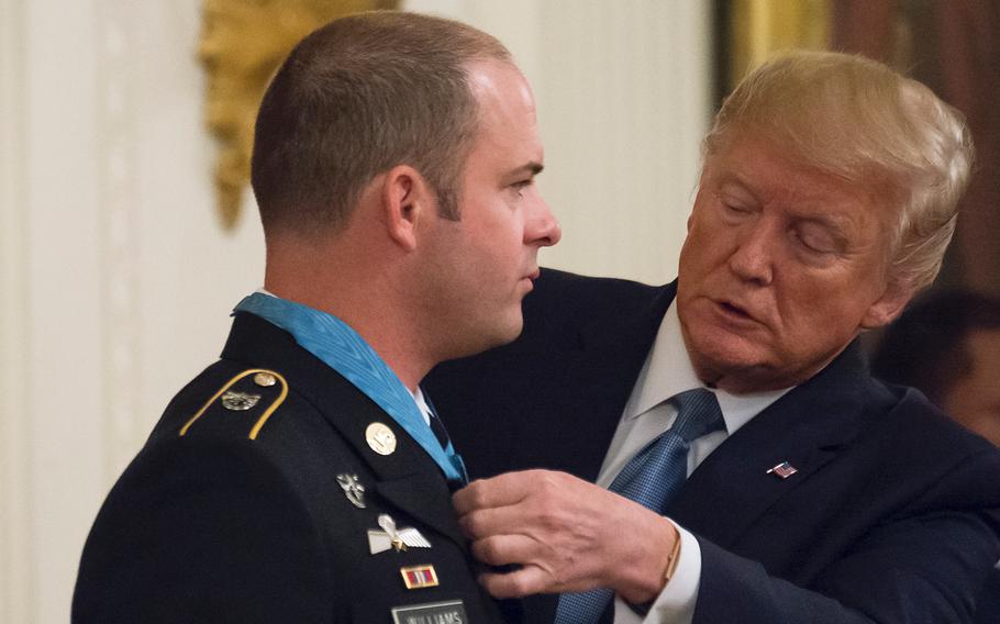 President Donald Trump straightens the Medal of Honor award he just fastened around the neck of Army Master Sgt. Matthew Williams during a ceremony at the White House on Wednesday, Oct. 30, 2019.
