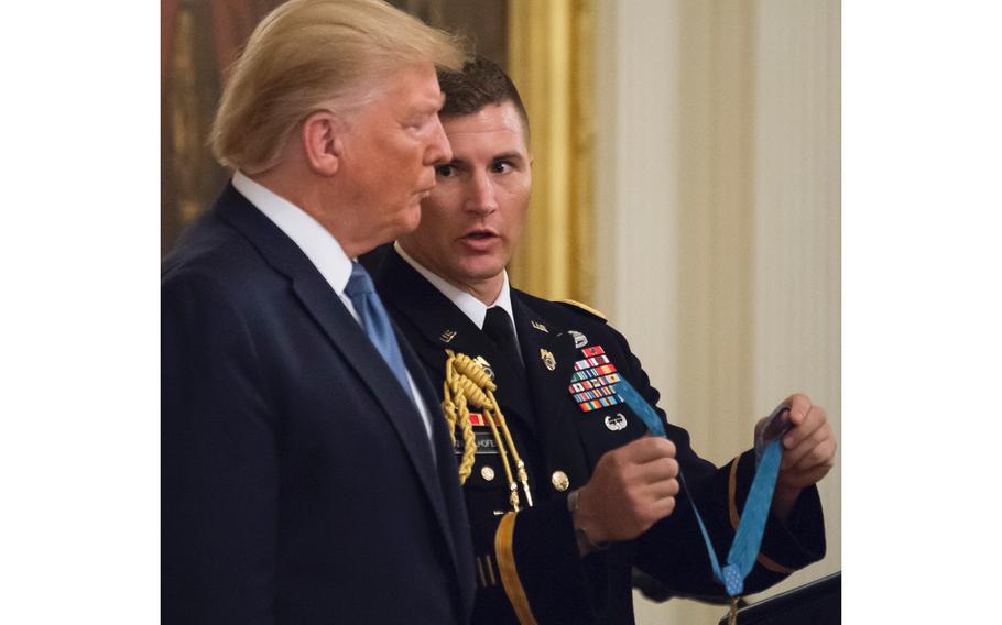 A White House military aide prepares to hand off a Medal of Honor award device to President Donald Trump during a ceremony at the White House on Wednesday, Oct. 30, 2019. The award was presented to Army Master Sgt. Matthew Williams for bravery under fire against enemy forces in an April 2008 battle in Afghanistan.