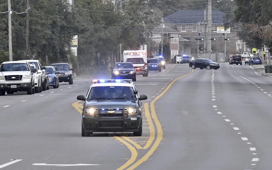 Police cars escort an ambulance after a shooter open fire inside the Pensacola Air Base, Friday, Dec. 6, 2019 in Pensacola, Fla. 