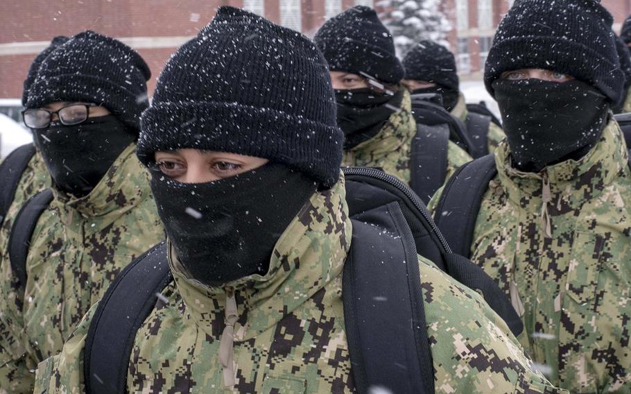 In a January, 2019 photo, recruits walk in formation wearing neck gaiters during a snowstorm at Recruit Training Command in Great Lakes, Ill.. 