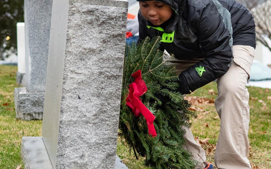 A young participant in Wreaths Across America places a wreath at the United States Naval Academy Cemetery in Annapolis, Md., December 13, 2019.