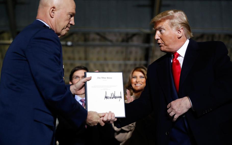 President Donald Trump shakes hands with Gen. Jay Raymond, after signing the letter of his appointment as the chief of space operations for U.S. Space Command during a signing ceremony for the National Defense Authorization Act for Fiscal Year 2020 at Andrews Air Force Base, Md., Friday, Dec. 20, 2019. 