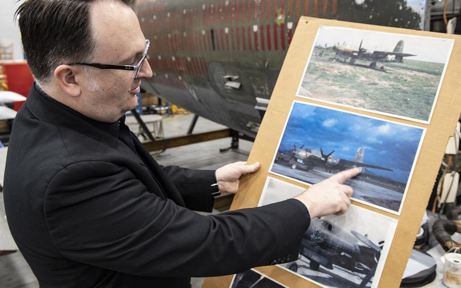 Aeronautics curator Jeremy Kinney points out details on a 1946 photo of the Martin B-26B-25-MA Marauder "Flak-Bait," in the background, being restored at the Smithsonian's Udvar-Hazy Center in January, 2020.
