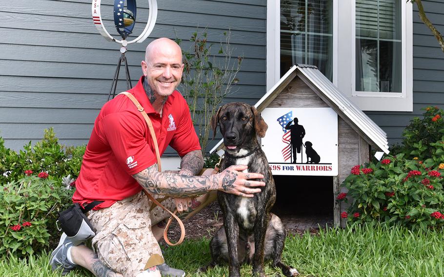 Damian Jungermann, 45, kneels with his service dog Shai, who turns two years old in March.