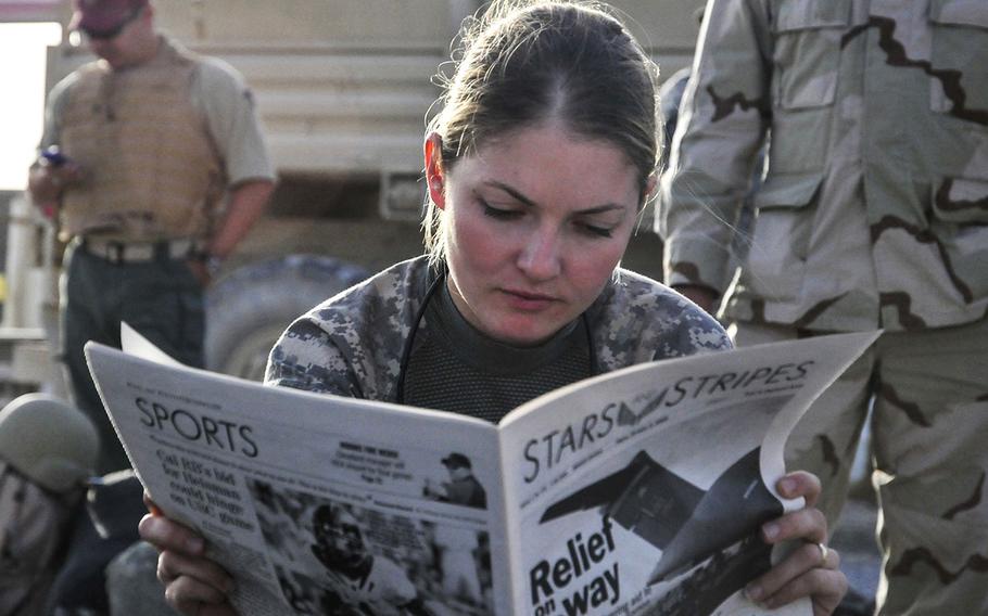 U.S. Army 1st Lt. Tracy Tyson, with 5th Brigade Combat Team, 2nd Infantry Division, reads the Stars and Stripes newspaper at Kandahar Airfield, Afghanistan, Oct. 5, 2009, while waiting for a flight to Forward Observation Base Wolverine.