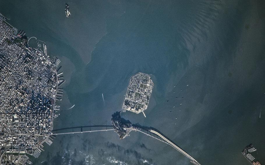 Alcatraz Island and Treasure Island can be seen near the center of this image of the San Francisco Bay, photographed with an 800mm lens some 215 to 220 miles above Earth in 2010. The image was taken by an Expedition 22 crew member aboard the International Space Station (ISS). San Francisco bay area structures including office buildings can be at the city's edge (left).