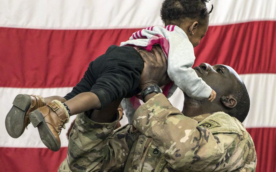 A paratrooper from 1st Brigade Combat Team, 82nd Airborne Division holds his daughter during a redeployment ceremony at Fort Bragg, N.C., February 20, 2020.