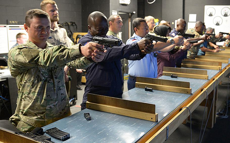 In a September, 2018 photo, training Security Assistance Field Activity foreign students try out the Gunner's Mate 'A' School's firearms training simulator at Center for Surface Combat Systems Unit Great Lakes, Ill.