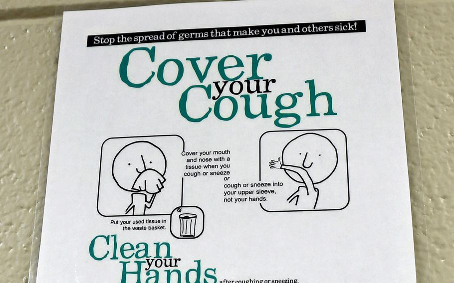 A germ prevention sign depicting proper etiquette to prevent the spread of coronavirus is posted on a wall at the 145th Medical Group on March 6, 2020 at the North Carolina (N.C.) Air National Guard Base, Charlotte Douglas International Airport.