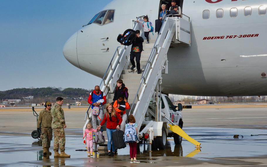 American troops and family members arrive on Osan Air Base, South Korea, on Friday, March 13, 2020, days after they were kicked off a military charter flight in Seattle amid confusion over an Army order halting moves amid the coronavirus crisis. 