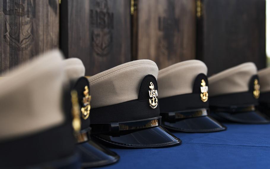 Chief petty officer combination covers lay on a table during a chief's pinning ceremony aboard the Arleigh Burke-class guided-missile destroyer USS Donald Cook, Sept. 15, 2019.